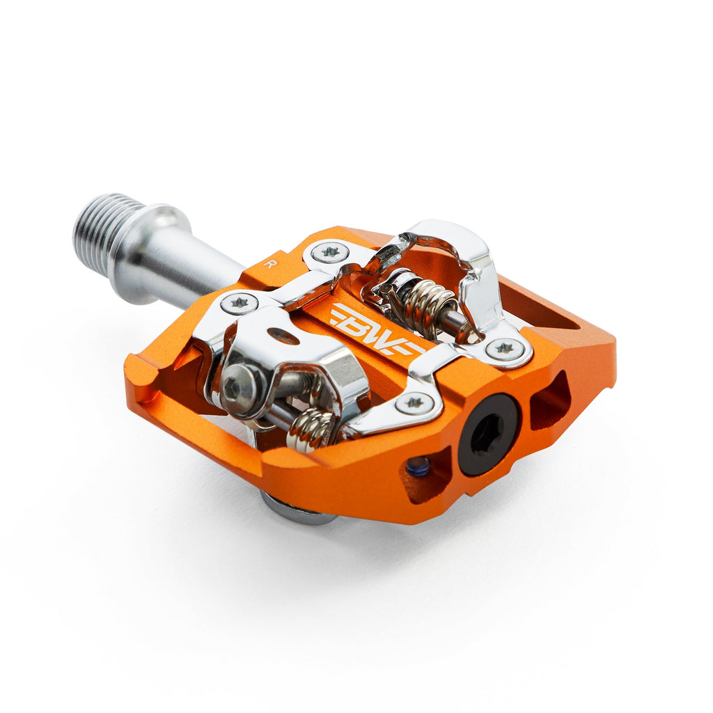 Orange clipless mountain bike pedal, corner view on white background. SPD compatible bicycle pedal.