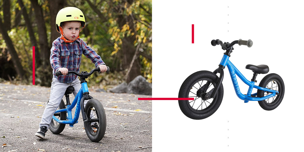 young boy riding blue balance bike outside on gravel road wearing a helmet