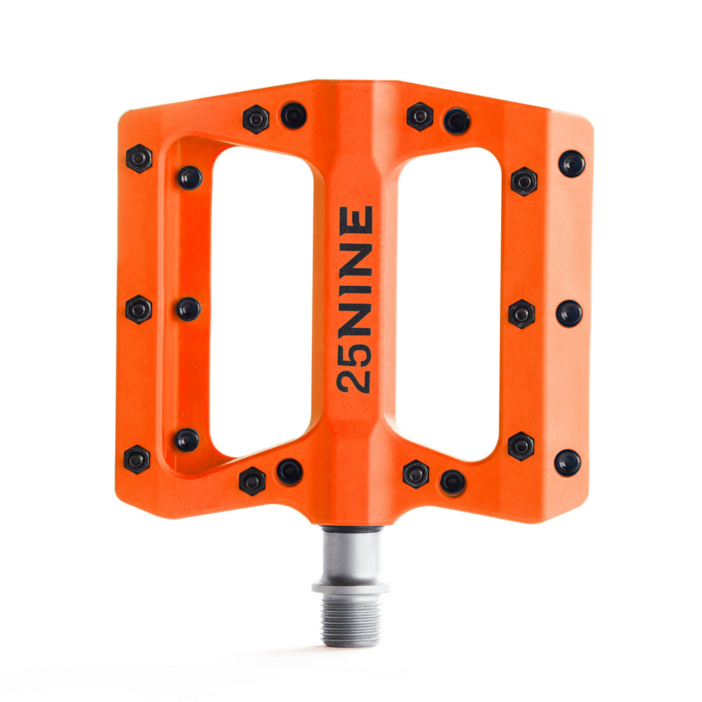 High traction bike pedal with removable pins. Orange bike pedal from a top view on a white background.