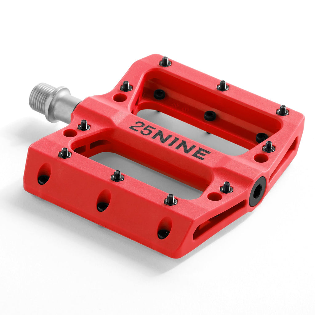 High traction bike pedal with removable pins. Red bike pedal from a corner view on a white background.