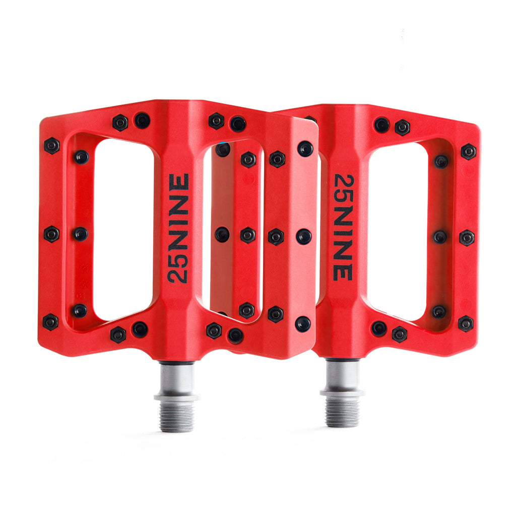 High traction bike pedals with removable pins. Red bike pedals from a top view on a white background.