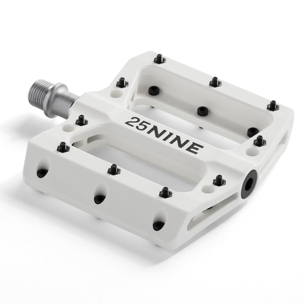 High traction bike pedal with removable pins. White bike pedal from a corner view on a white background.