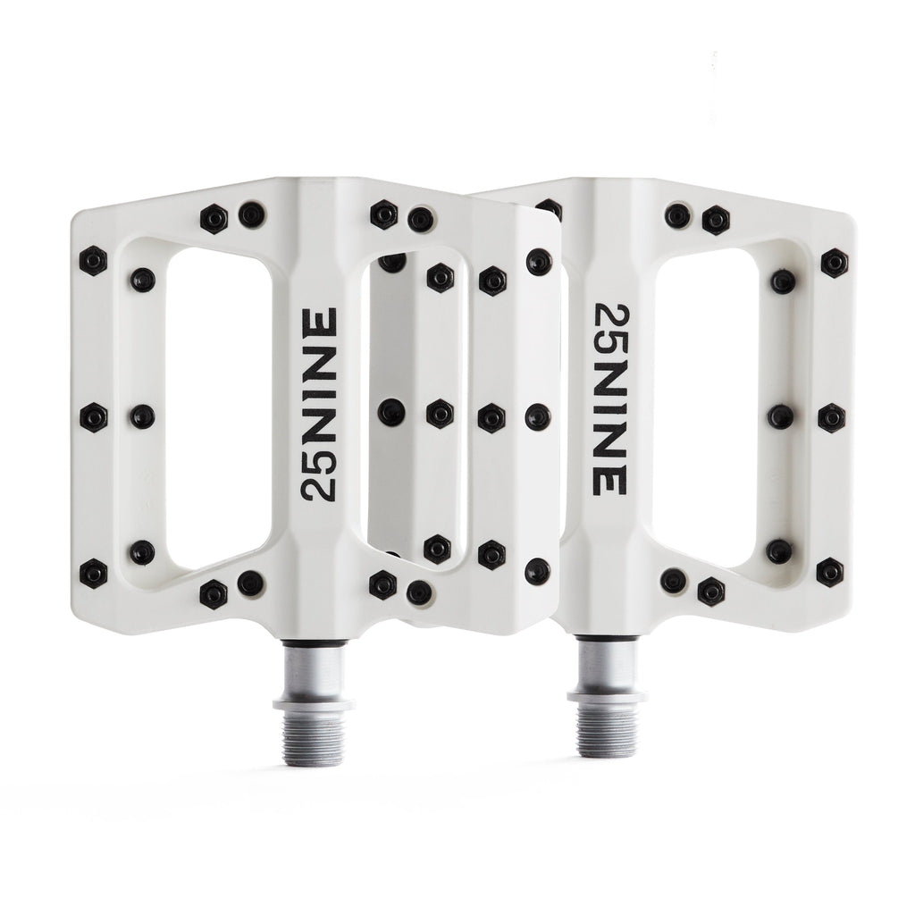 High traction bike pedals with removable pins. White bike pedals from a corner view on a white background.