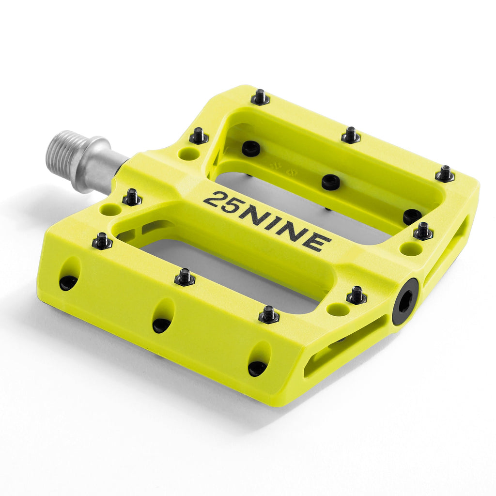 High traction bike pedal with removable pins. Yellow bike pedal from a corner view on a white background.