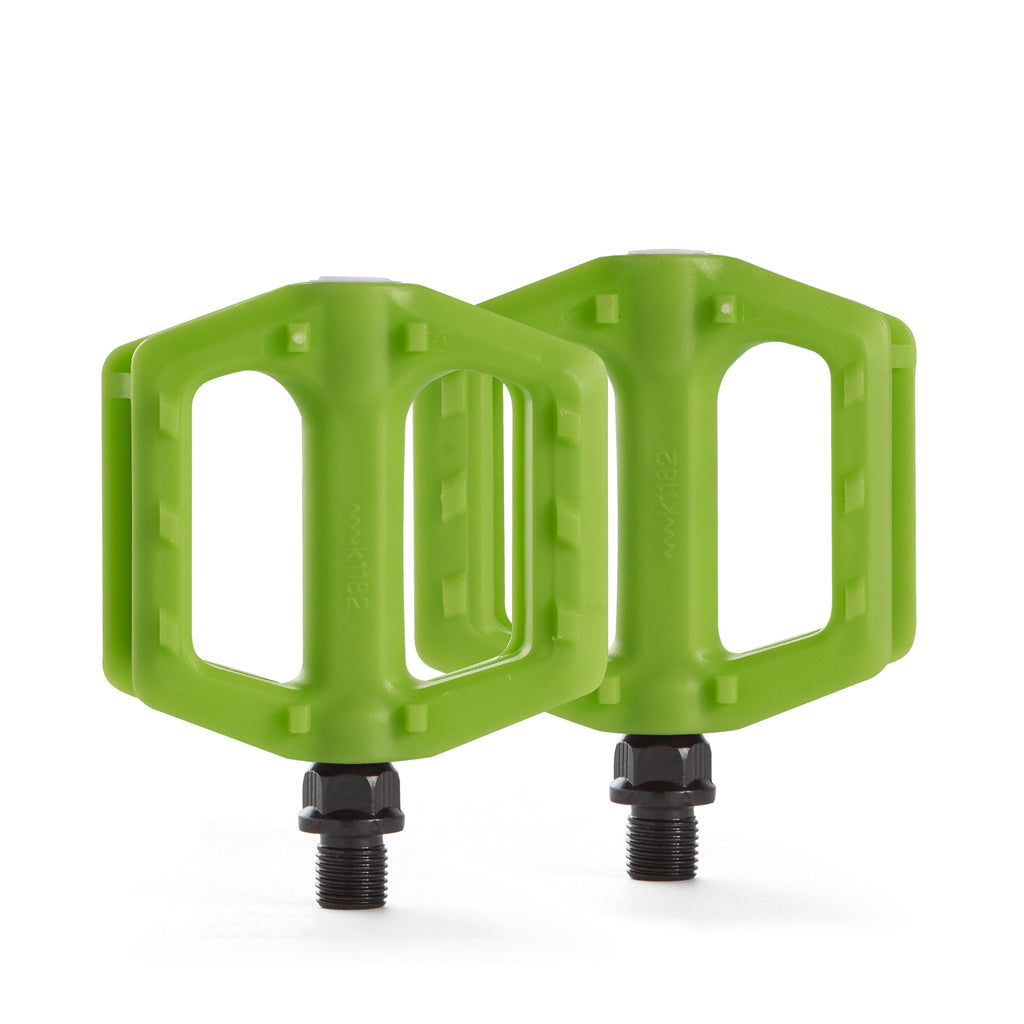 green bicycle pedals for youth upright with white background