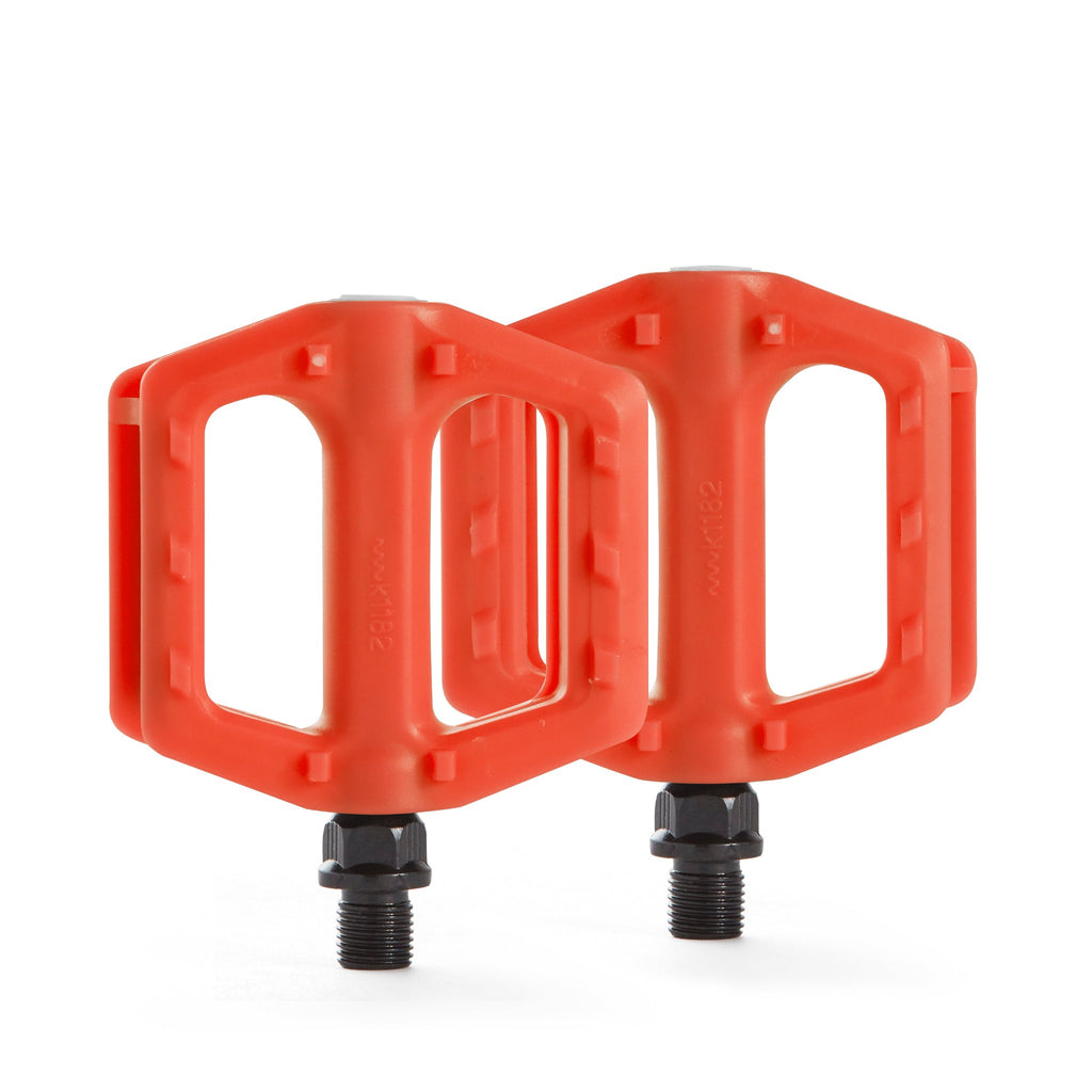 kids orange bike pedals. Top down view with white background.
