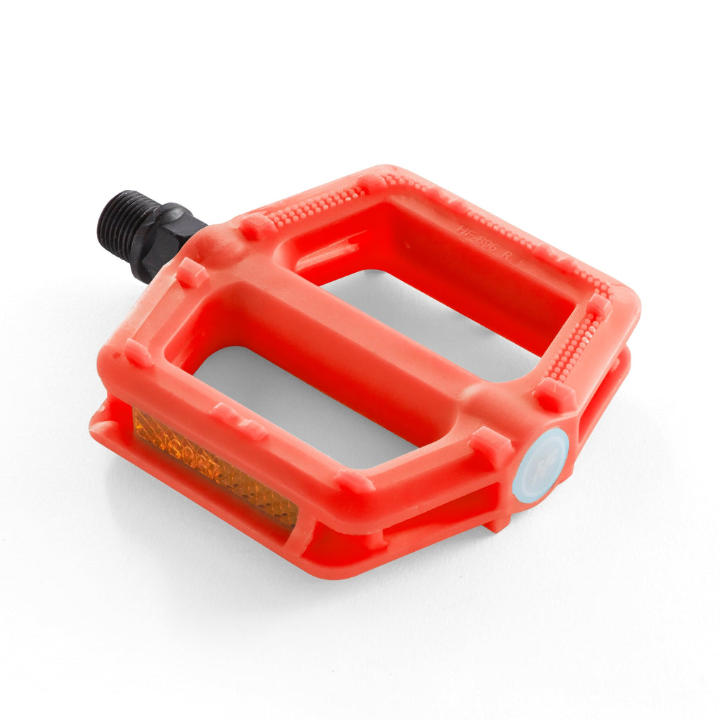 One orange bike pedal for kids. Angled overhead view with a white background.