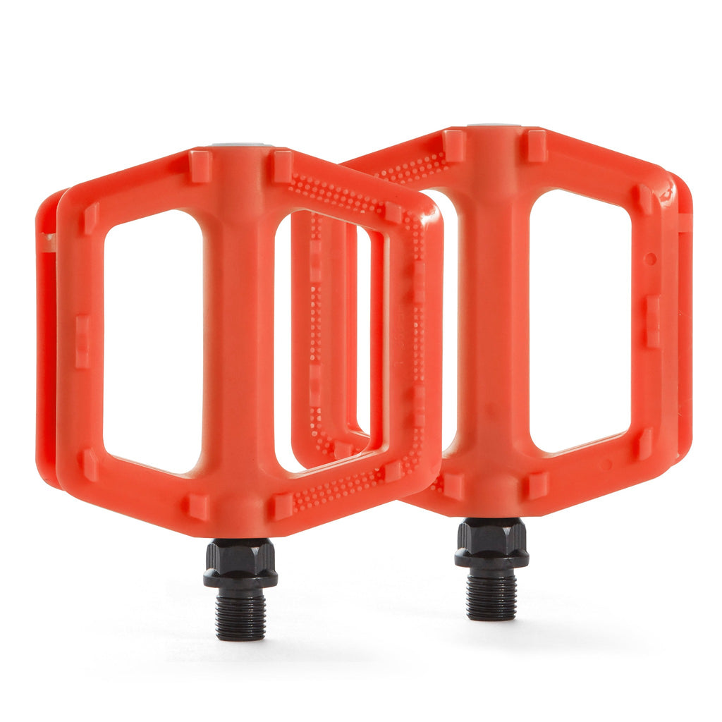 Two orange bicycle pedals for kids. Overhead view with a white background.