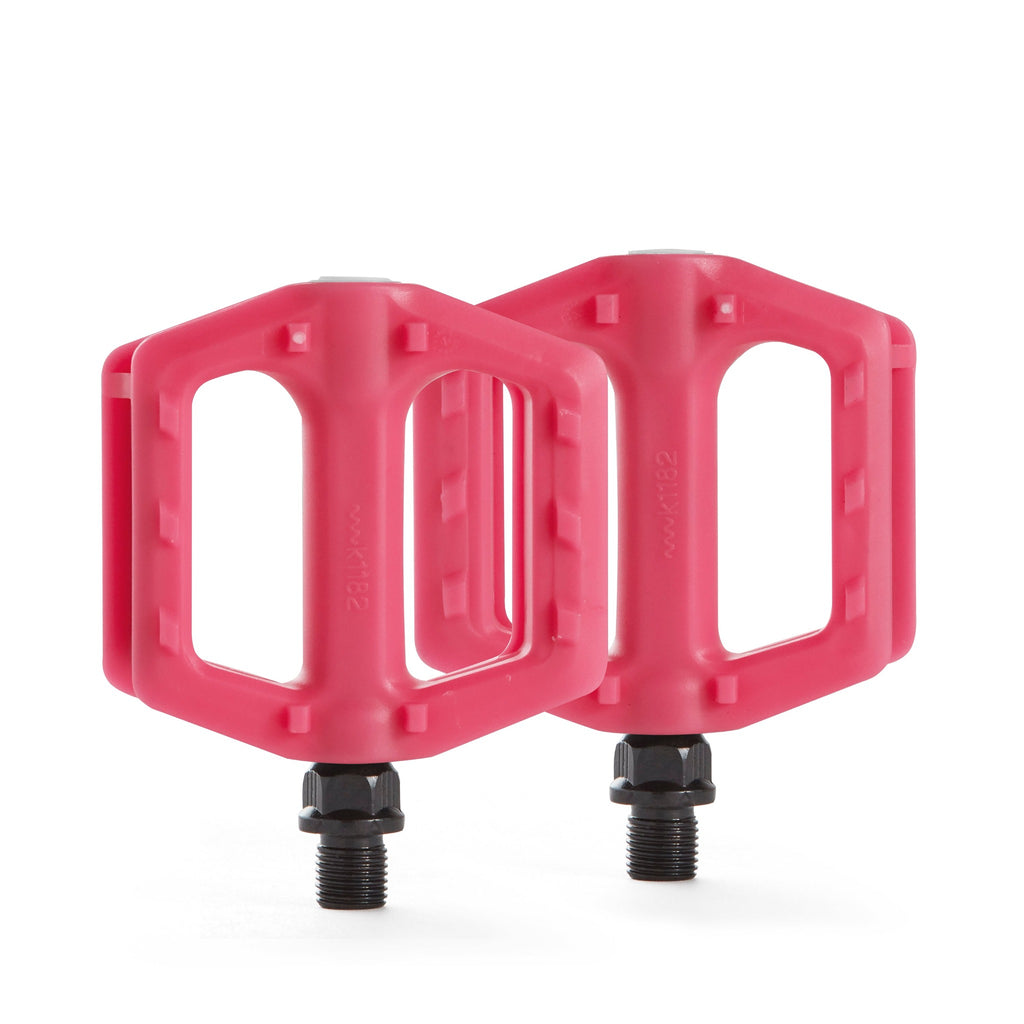Kids bike pedals in the color pink. Top down view with white background.