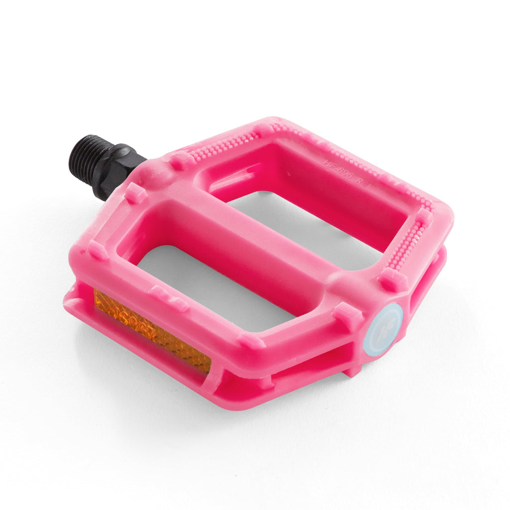 One pink bike pedal for kids. Angled overhead view with a white background.