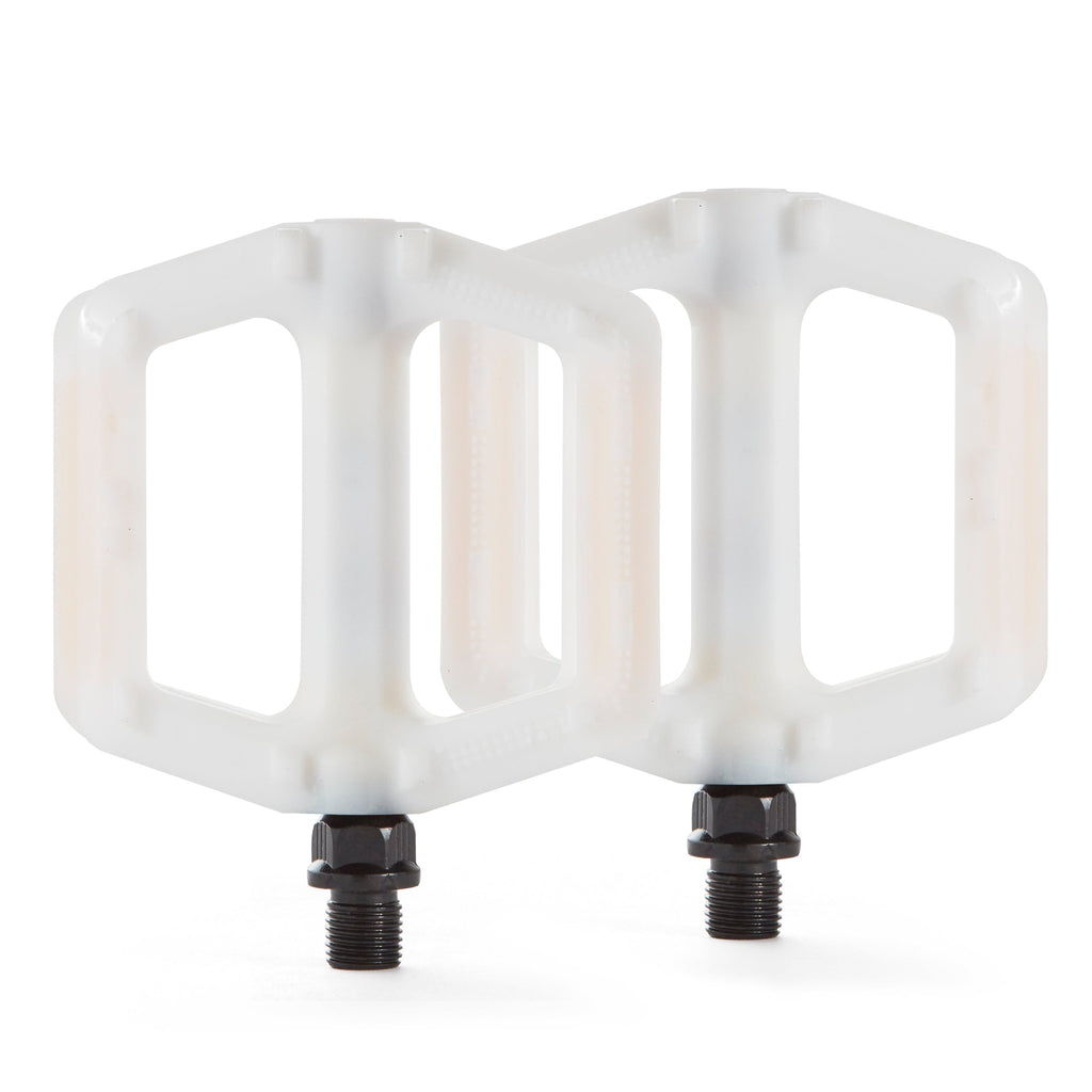 A pair of white bicycle pedals for kids. Overhead view with a white background.