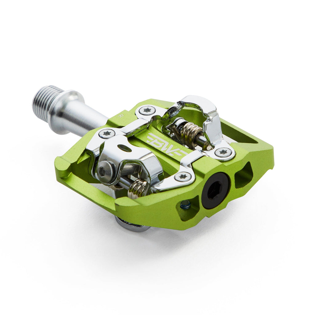 Green clipless mountain bike pedal, corner view on white background. SPD compatible bicycle pedal.