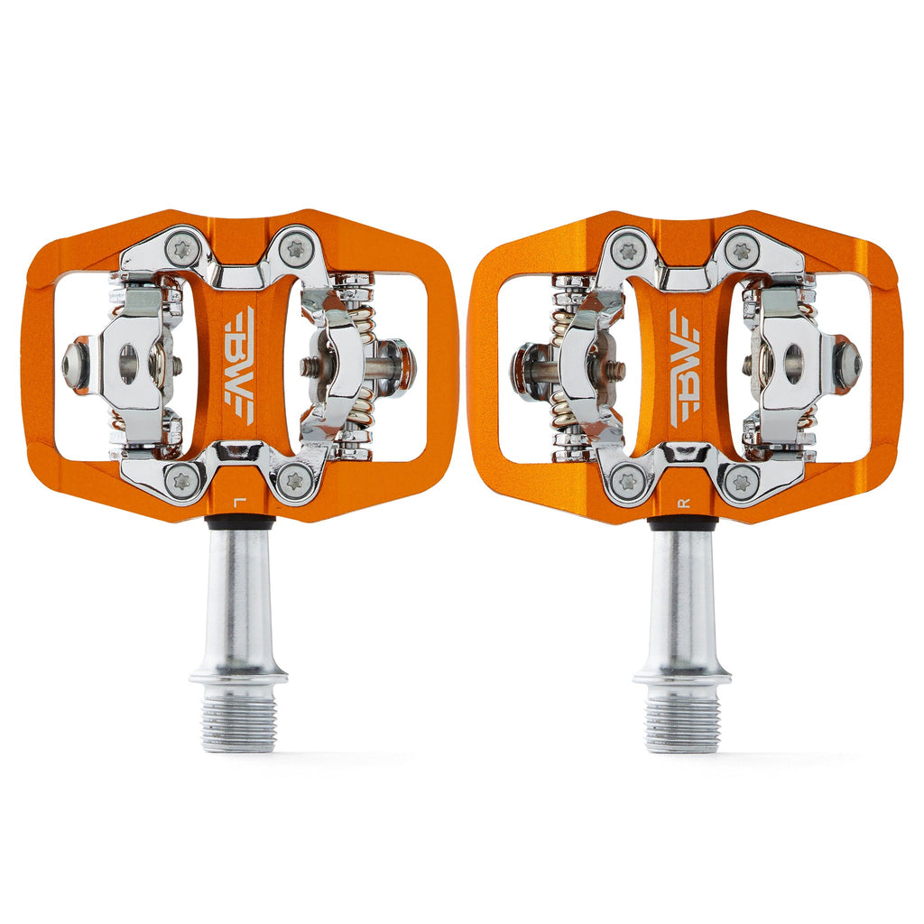 Orange clipless mountain bike pedals, top view on white background. SPD compatible bicycle pedals.