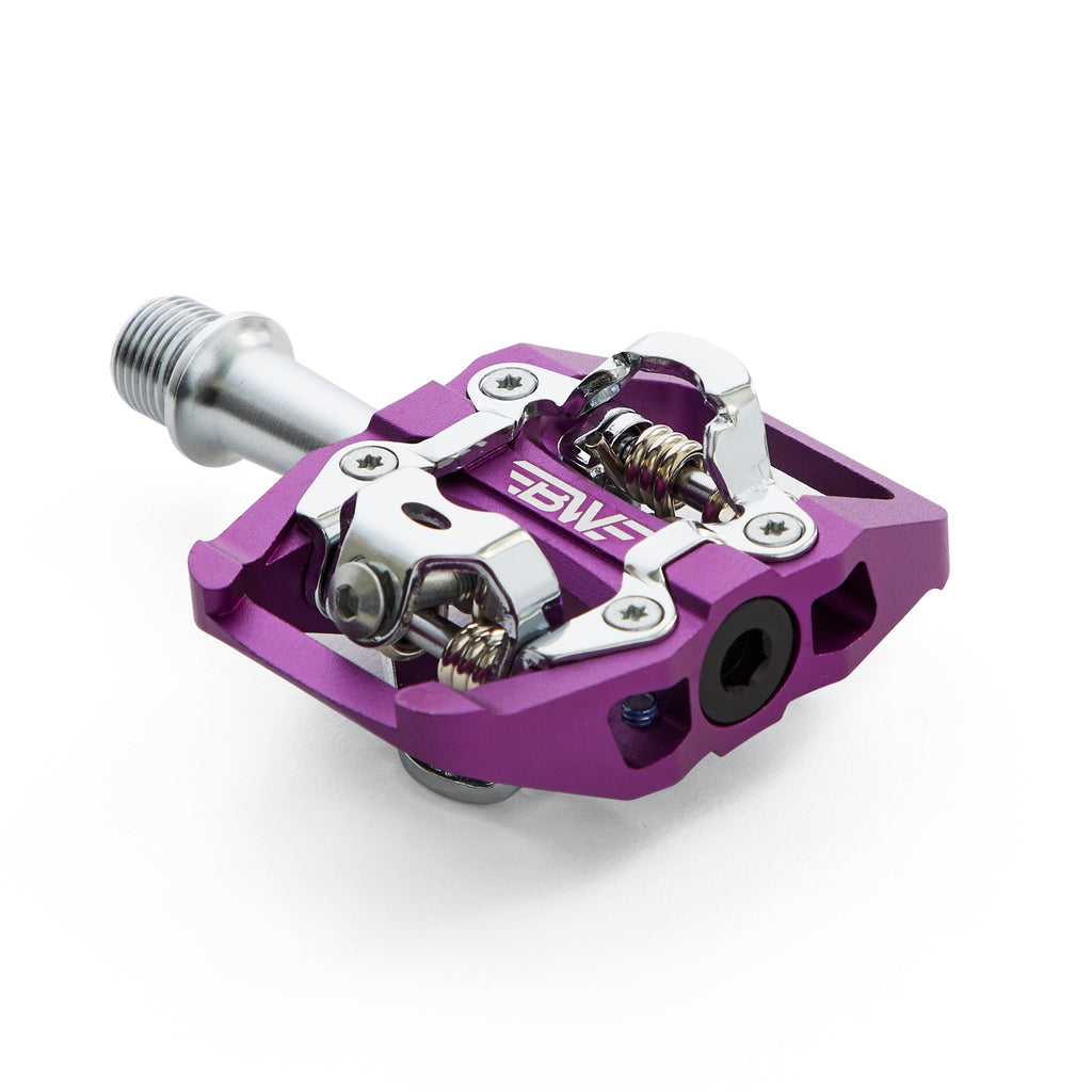 Purple clipless mountain bike pedal, corner view on white background. SPD compatible bicycle pedal.