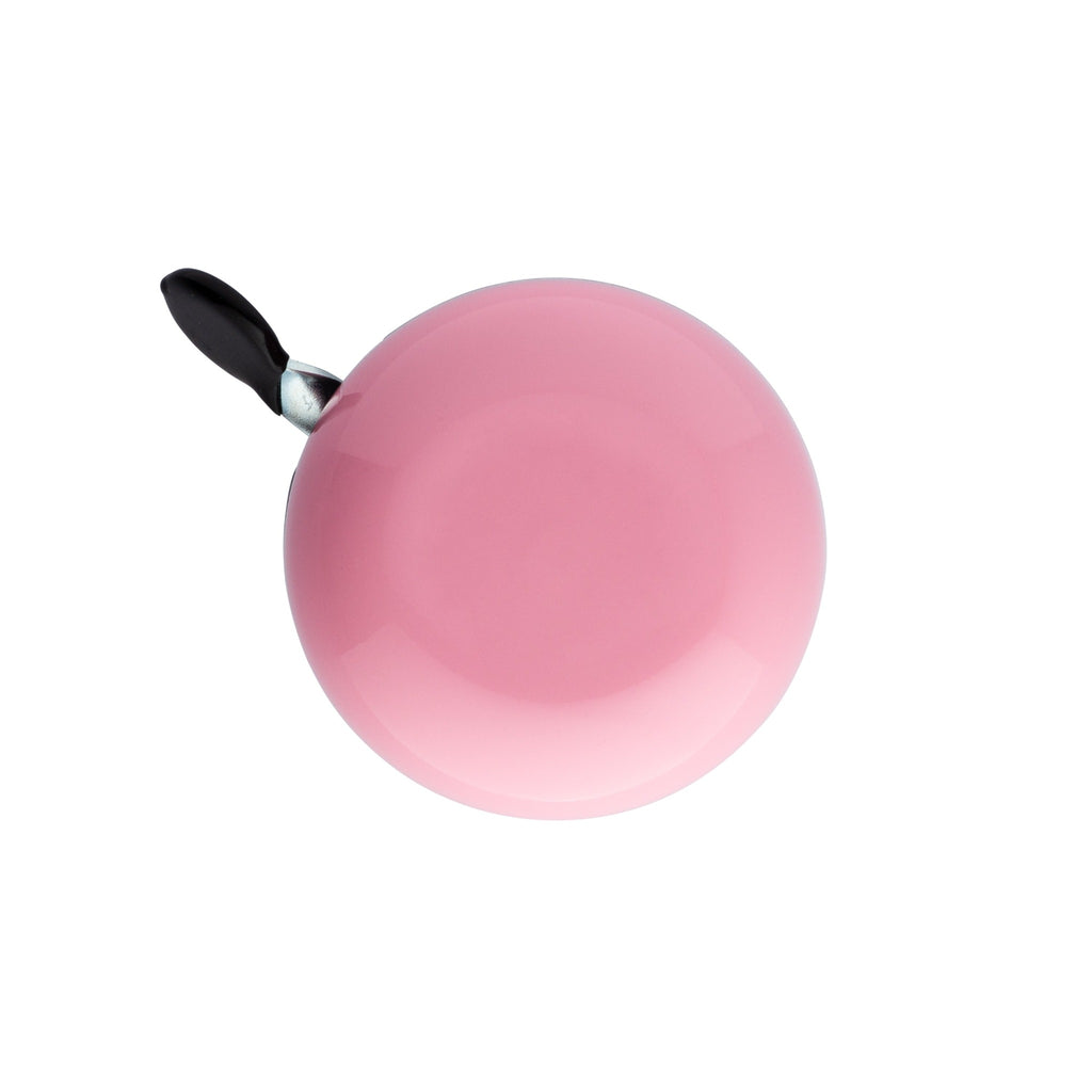 Handlebar bike bell with classic ding dong sound. Color blush pink on a white background. Top view of vintage style bike bell.
