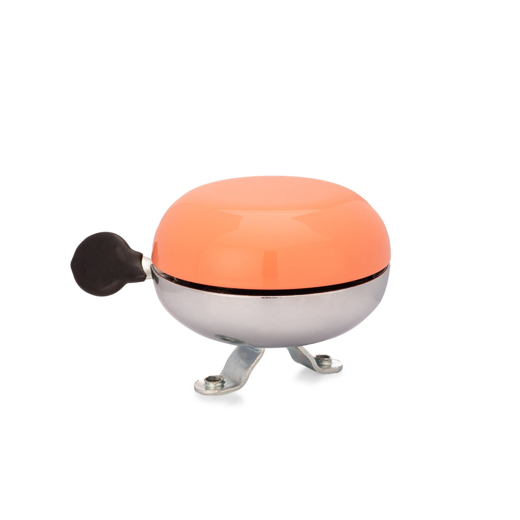 Handlebar bike bell with classic ding dong sound. Color coral on a white background. Side view of vintage style bike bell.