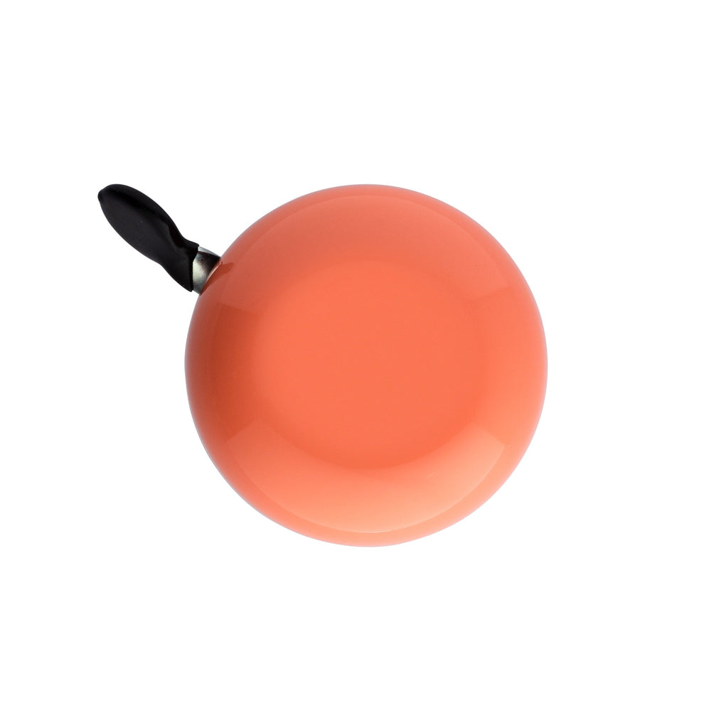 Handlebar bike bell with classic ding dong sound. Color coral on a white background. Top view of vintage style bike bell.