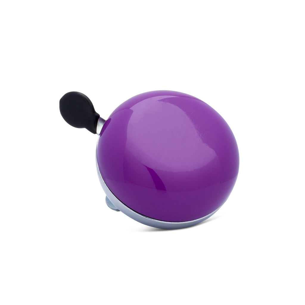 Purple bike bell with classic ding dong sound. Corner view with white background. Vintage style bike bell.