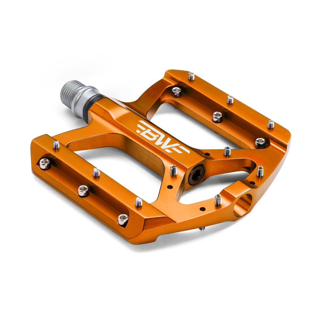 Orange mountain bike pedal on white background.