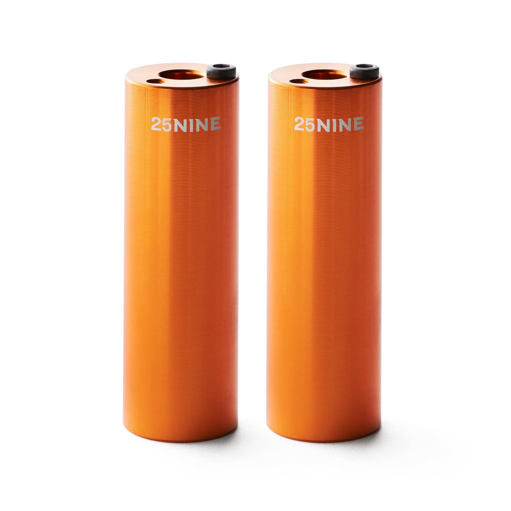 Set of orange bmx pegs with white background.
