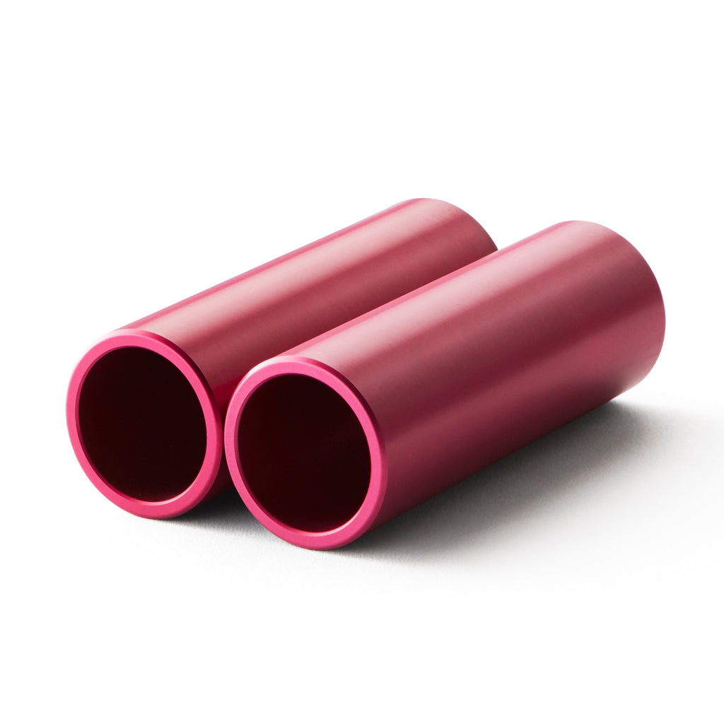 Set of pink bmx pegs with white background.