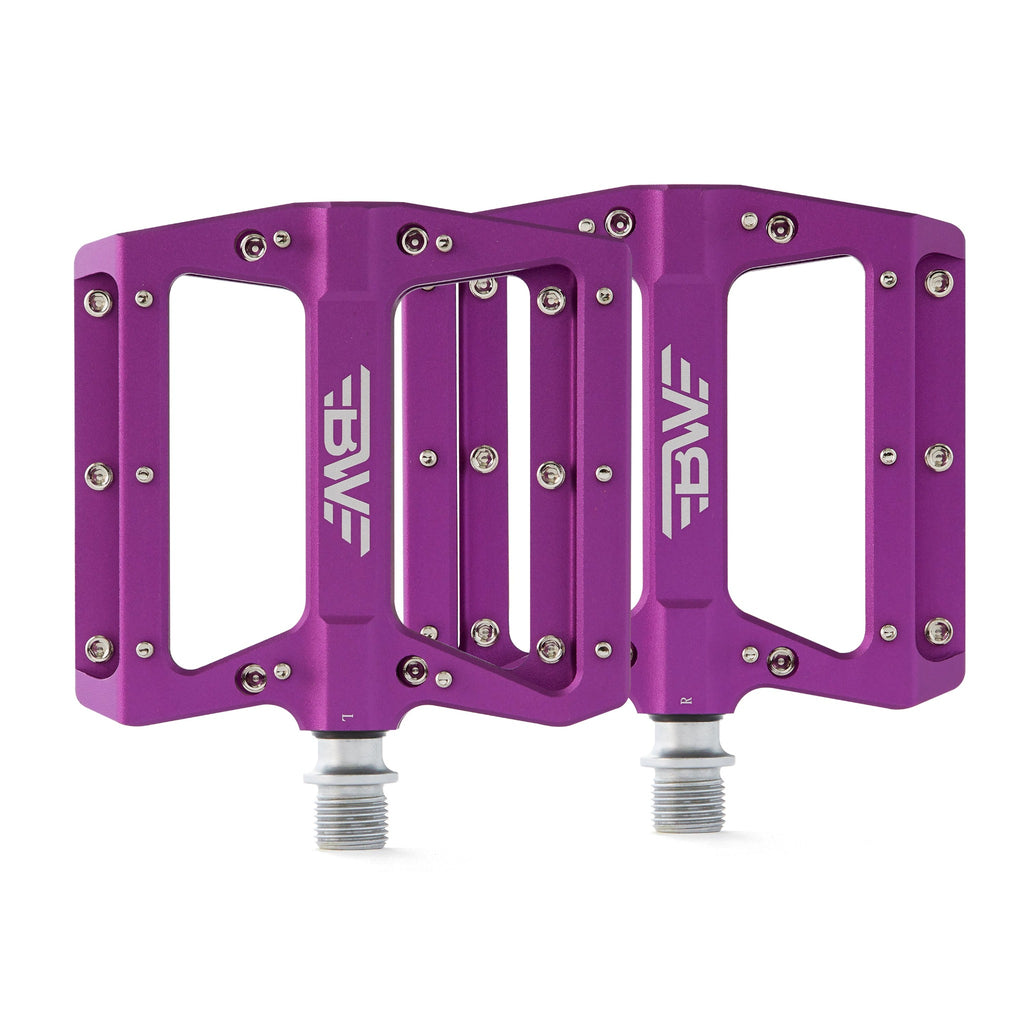 Large platform mountain bike pedals with replaceable traction pins. Purple mountain bike pedals viewed from the top on a white background.