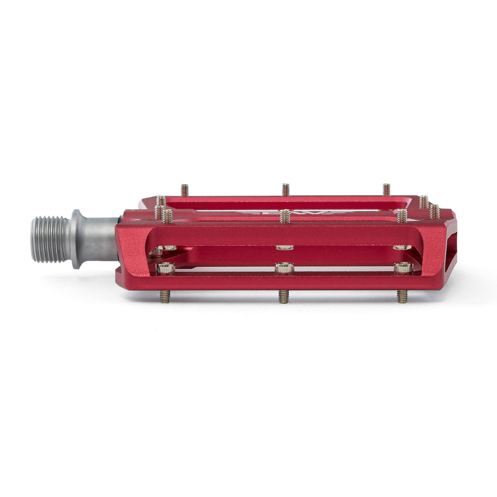 Large platform mountain bike pedal with replaceable traction pins. Red mountain bike pedal profile view from the front with a white background.