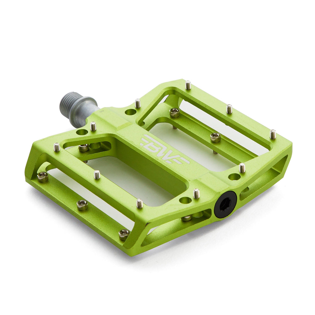 Large platform mountain bike pedal with replaceable traction pins. Green mountain bike pedal viewed from the corner on a white background.