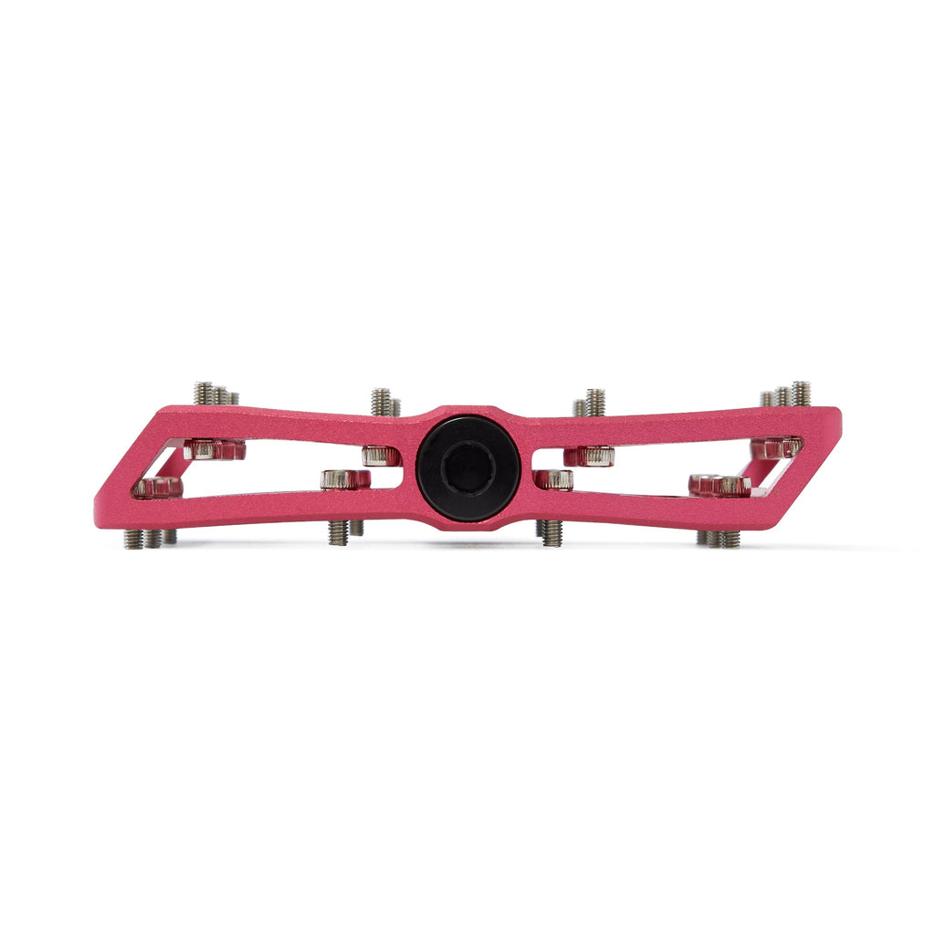 Large platform mountain bike pedal with replaceable traction pins. Pink mountain bike pedal viewed from the side on a white background.