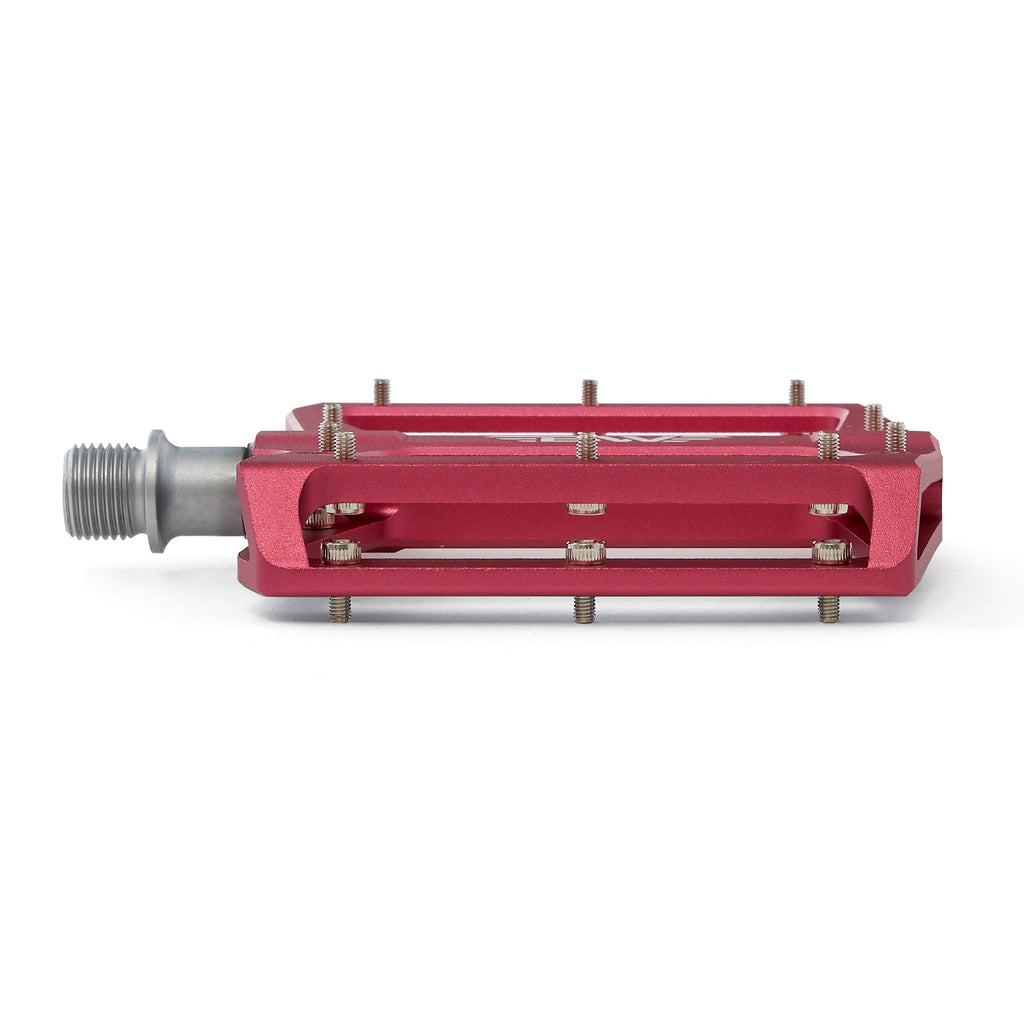 Large platform mountain bike pedal with replaceable traction pins. Pink mountain bike pedal viewed from the front on a white background.