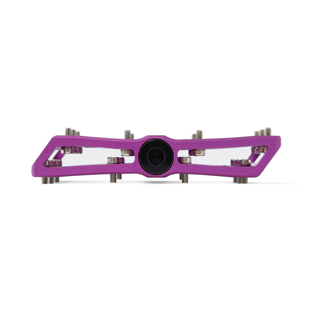 Large platform mountain bike pedal with replaceable traction pins. Purple mountain bike pedal viewed from the side with a white background.
