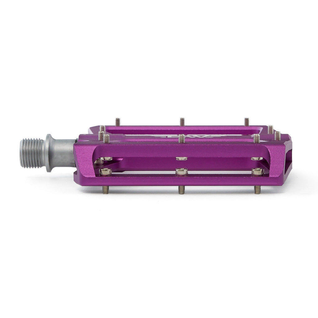 Large platform mountain bike pedal with replaceable traction pins. Purple mountain bike pedal viewed from the front with a white background.