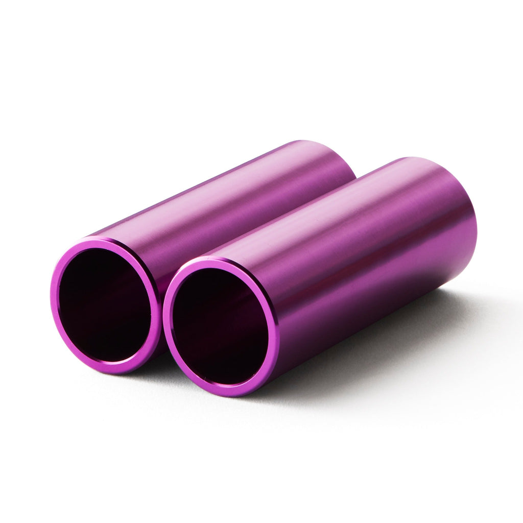 Set of purple bmx pegs with white background.