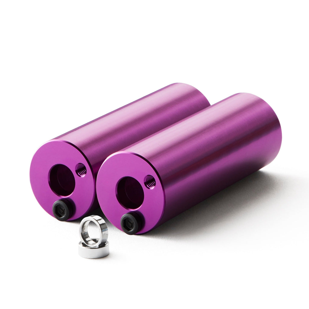 Set of purple bmx pegs with white background.