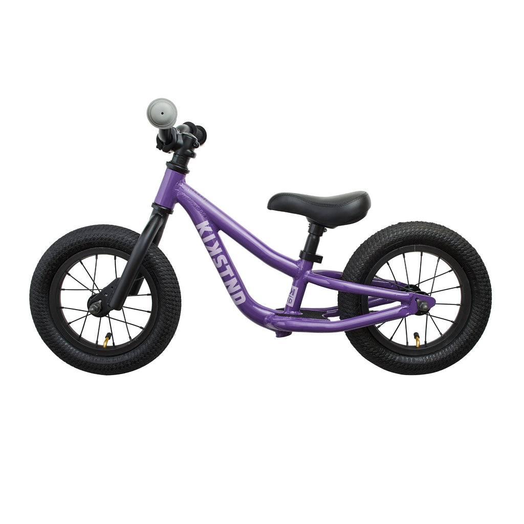 Side view of kids balance bike. Purple balance bike on white background.