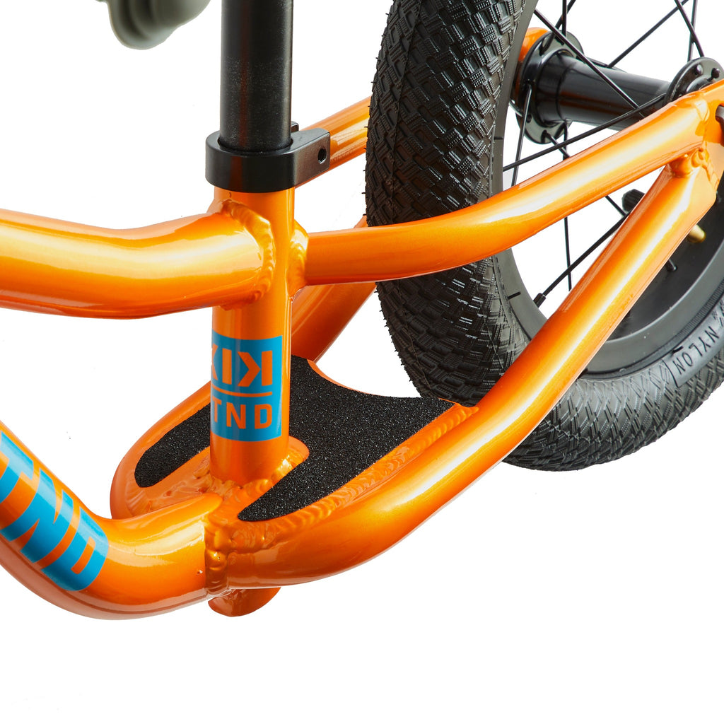 foot platform on kids balance bike. Orange balance bike on white background.