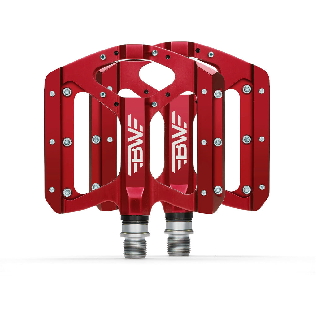 Red mountain bike pedals on white background.