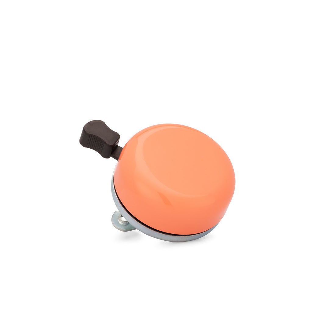 Classic bicycle bell colored coral, corner view on white background. Vintage style bicycle bell.