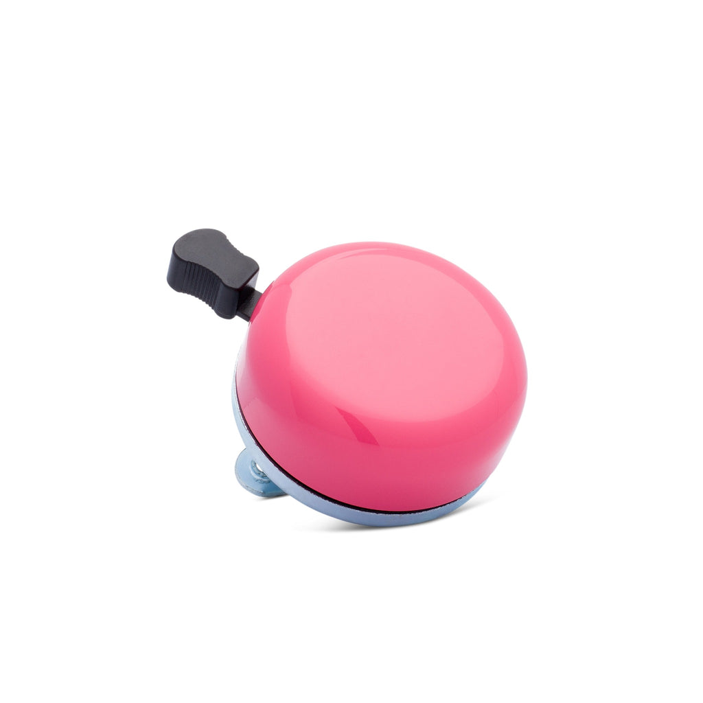 Classic bicycle bell color modern pink, corner view on white background. Vintage style bicycle bell.