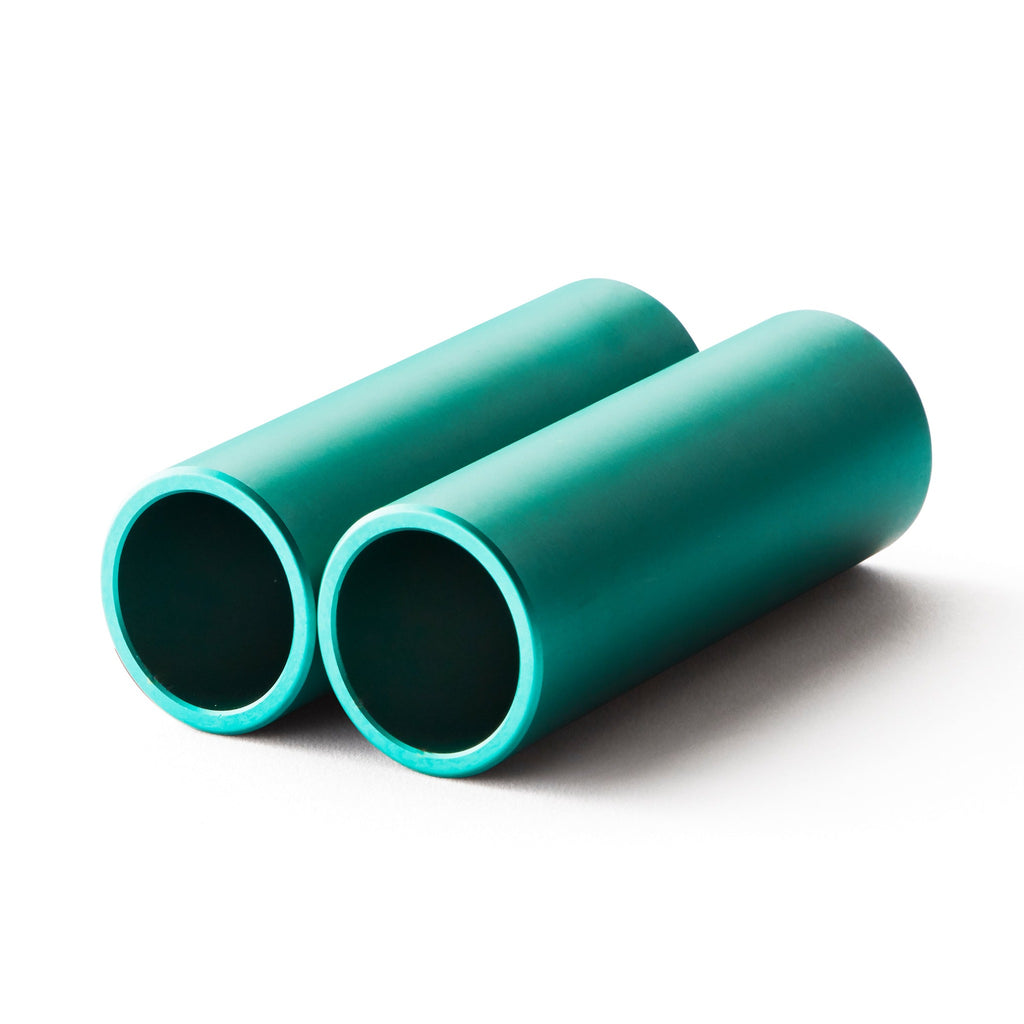 Set of teal bmx pegs with white background.