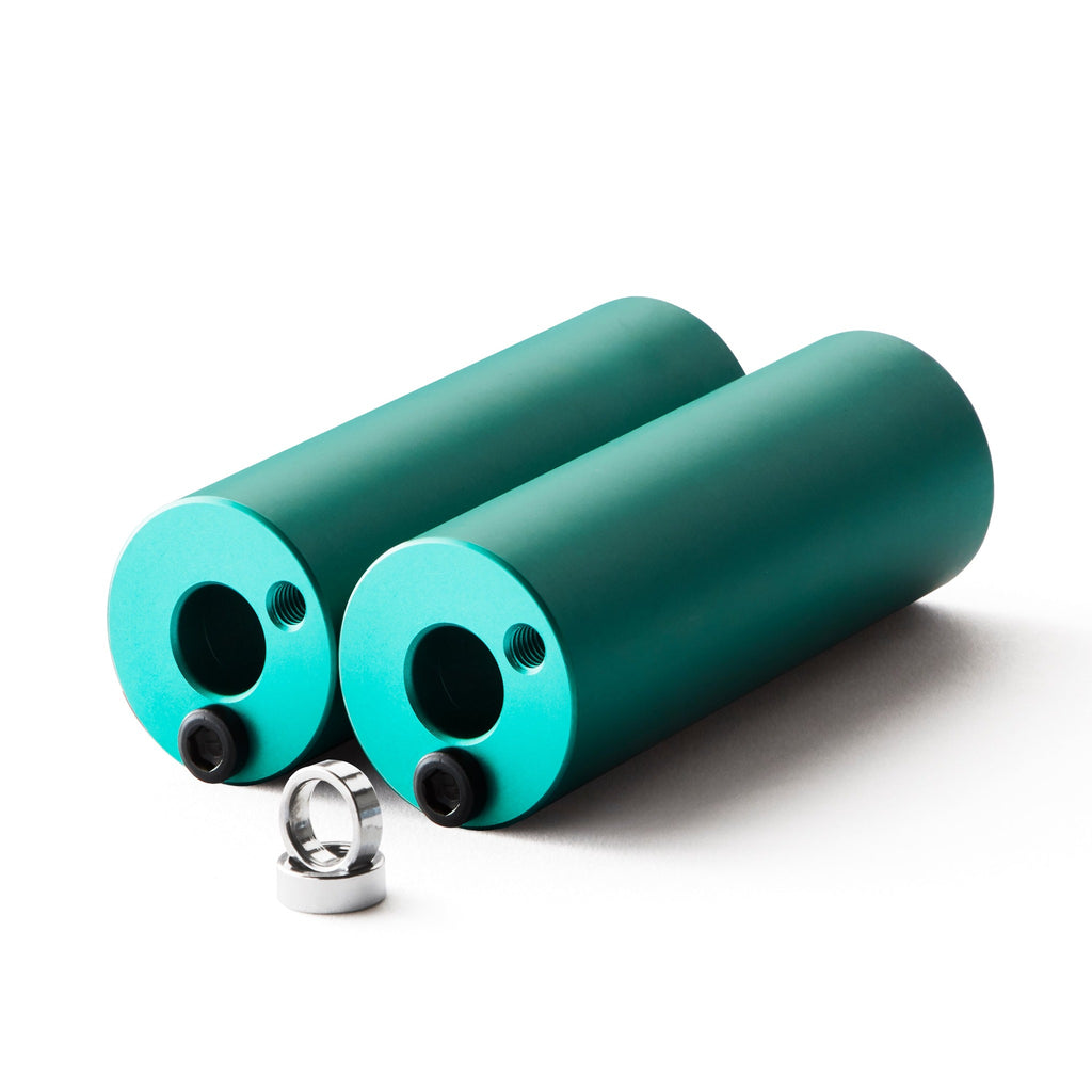 Set of teal bmx pegs with white background.